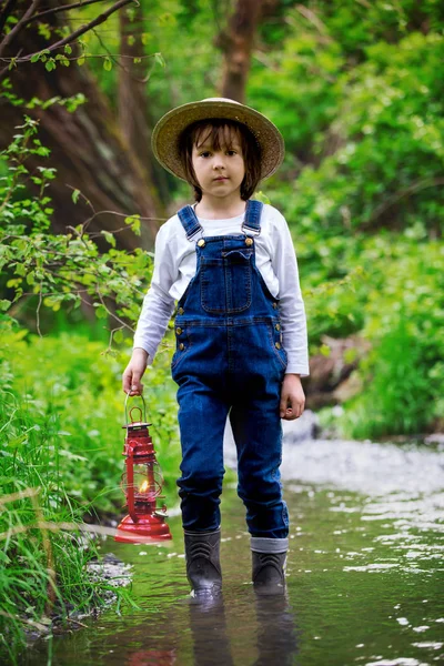 Sweet child, boy, holding red gas lamp, lantern — Stock Photo, Image