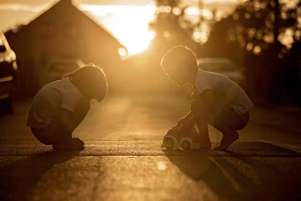Duas crianças doces, meninos irmãos, brincando com brinquedos de carro no s — Fotografia de Stock