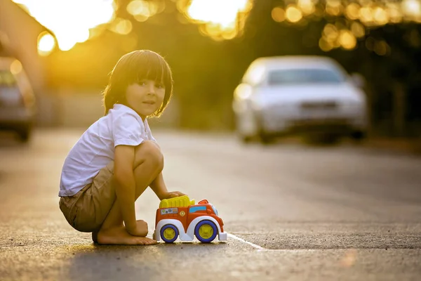 Dwa słodkie dzieci, chłopak braci, bawi się zabawkami samochodów na s — Zdjęcie stockowe