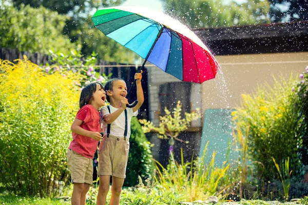 Two adorable children, boy brothers, playing with colorful umbre — Stock Photo, Image