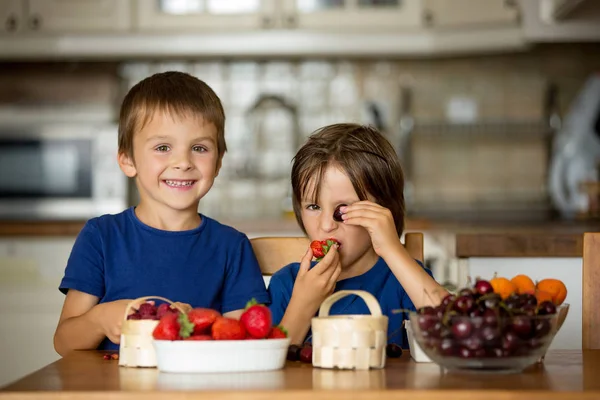 Deux doux enfants, garçons frères, mangeant des fruits frais à la maison — Photo