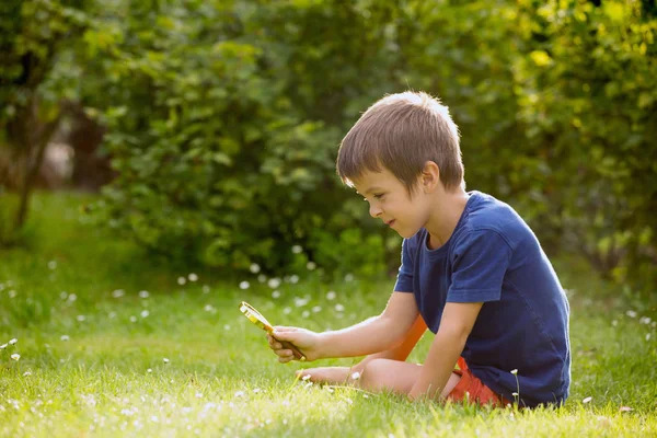 Criança feliz bonita, menino, explorando a natureza com gla de aumento — Fotografia de Stock