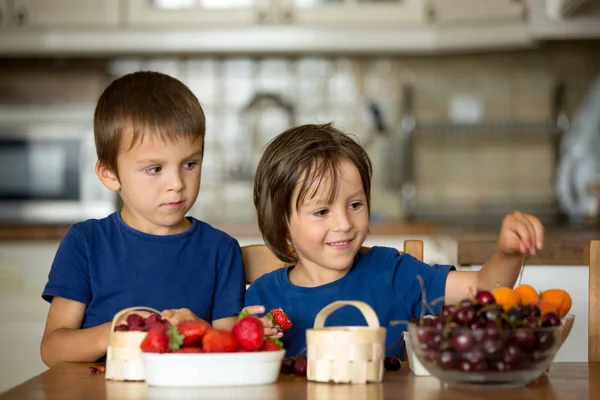 Two sweet children, boy brothers, eating fresh fruits at home — Stock Photo, Image