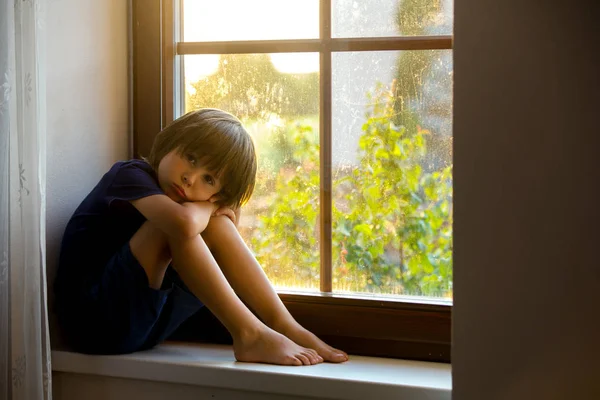 Triste enfant, garçon, assis sur un bouclier de fenêtre — Photo