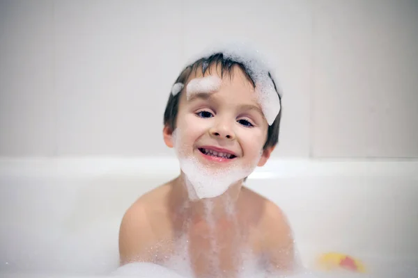 Ładny chłopak w wannie, uśmiechnięty, pokryty pianką protokołu soap — Zdjęcie stockowe