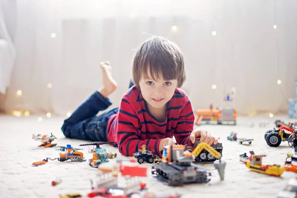 Little child playing with lots of colorful plastic toys indoor — Stock Image Little child playing with lots of colorful plastic toys indoor Royalty Free Stock Images