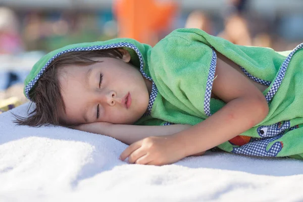 Pequeño niño, durmiendo en la playa por la tarde — Foto de Stock