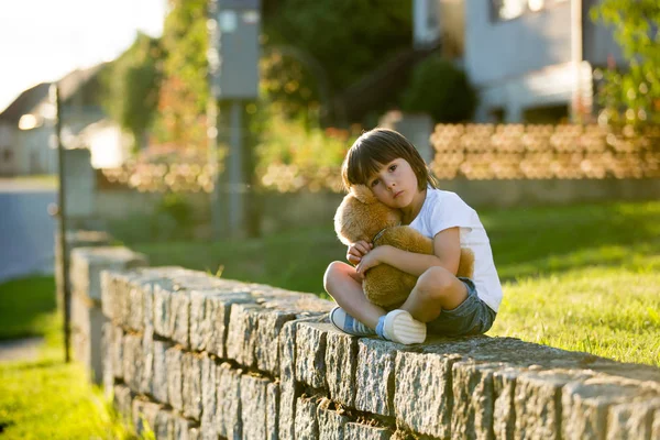 Dulce niño, jugando con el oso de peluche en un pequeño camino rural en los soles —  Fotos de Stock