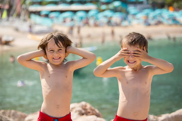 Two children on the beach, boys, playing and making funny faces — Stock Photo, Image