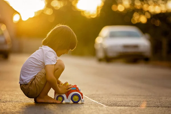 Dos niños dulces, hermanos, jugando con juguetes de coche en el s —  Fotos de Stock