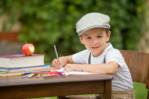 Chico, escribiendo sus deberes desde la escuela, dibujando y escribiendo en hola — Foto de Stock