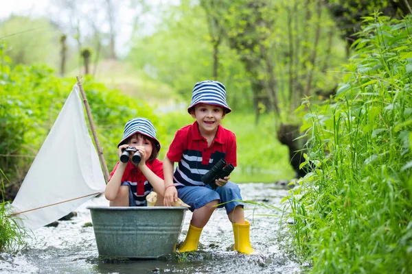 Roztomilé děti, chlapci, hraní s lodí a kachny na trochu riv — Stock fotografie