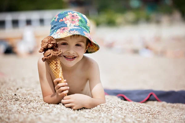 Солодка маленька дитина, хлопчик, їсть морозиво на пляжі — стокове фото