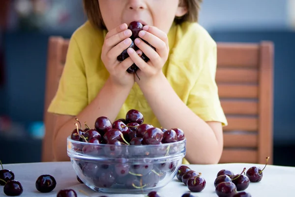 Cute little boy, eating sweet cherry outdoors — Stock Photo, Image