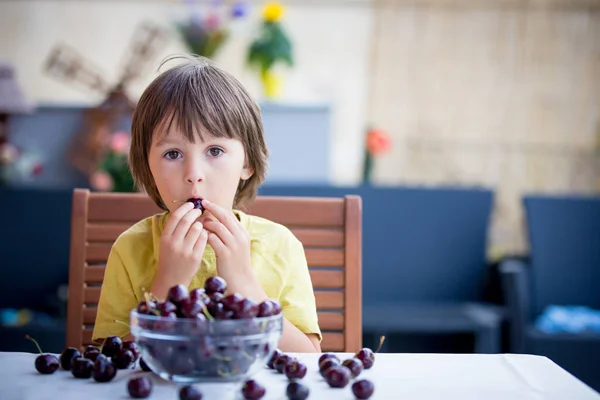 Cute little boy, eating sweet cherry outdoors — Stock Photo, Image