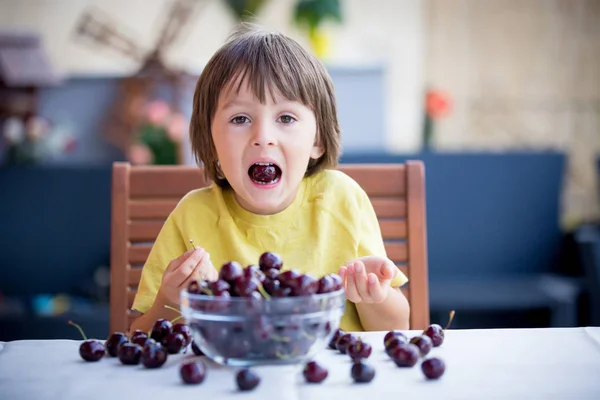 Cute little boy, eating sweet cherry outdoors — Stock Photo, Image