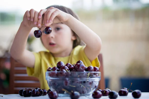 Cute little boy, eating sweet cherry outdoors — Stock Photo, Image