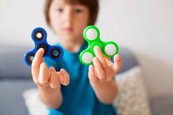 Lilla barn, pojke, leker med gröna och blå lysande fidget s — Stockfoto