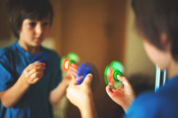 Criança, menino, brincando com verde e azul luminoso fidget s — Fotografia de Stock