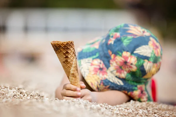 Солодка маленька дитина, хлопчик, їсть морозиво на пляжі — стокове фото