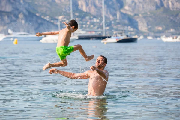 孩子和他的父亲，在海洋里，开心孩子在跳 — 图库照片