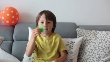 Küçük çocuk, çocuk, evde stres rahatlatmak için yeşil ışık saçan topluca spinner oyuncakla oynamak