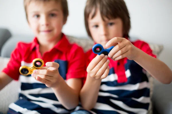 Malé děti, chlapec bratři, hrát si s barevnými neposeda spin — Stock fotografie