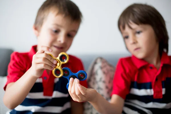 Little children, boy brothers, playing with colorful fidget spin — Stock Photo, Image