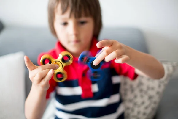 Little child, boy, playing with two fidget spinner toys — Stock Photo, Image