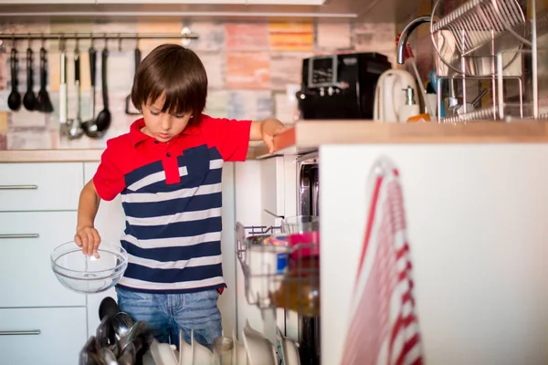 Criança pré-escolar, menino, ajudando a mãe, colocando pratos sujos na louça — Fotografia de Stock