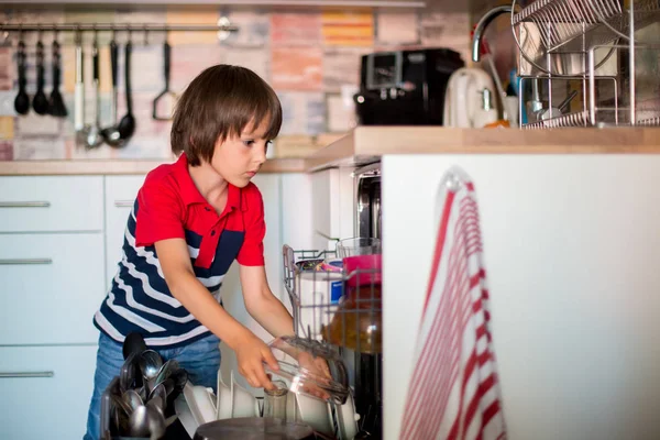 Preschool child, boy, helping mom, putting dirty dishes in dishw — Stock Photo, Image