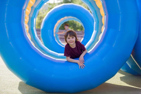 Menino bonito, jogando em um anel de cilindro de plástico rolante, ful — Fotografia de Stock