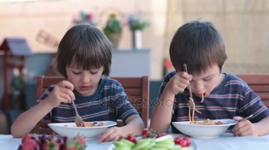 Sevimli çocuklar, okul öncesi çocuklar, spagetti için Bahçe, yaz aylarında açık havada yemek yeme