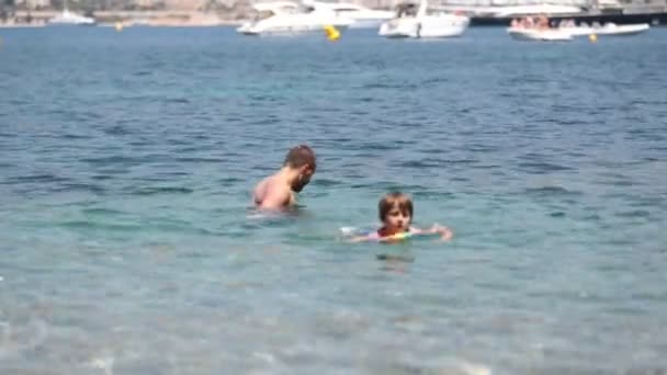 Criança e seu pai, se divertindo no mar, garoto pulando na água, pai jogando-o alto — Vídeo de Stock