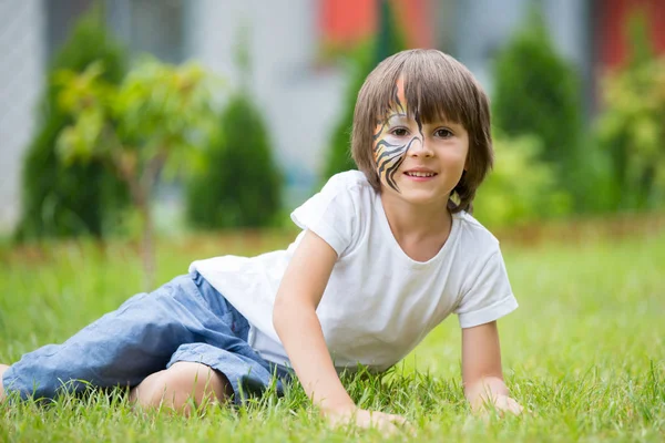 Dulce niño preescolar, pintado como tigre, jugando en el jardín —  Fotos de Stock