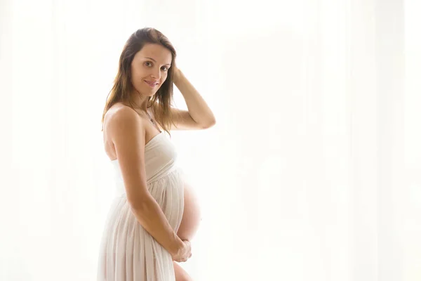 Портрет молодої вагітної привабливої жінки, що стоїть за перемогою — стокове фото