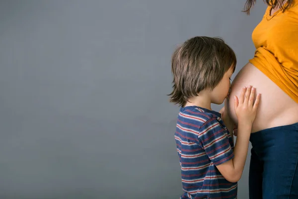 Little child, boy, hugging his pregnant mother at home, isolated — Stock Photo, Image