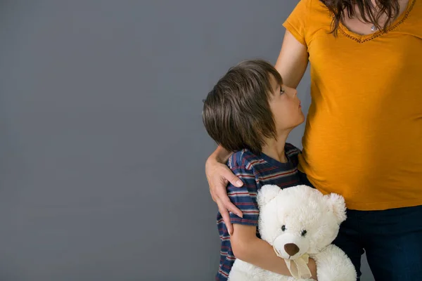 Klein kind, jongen, knuffelen zijn zwangere moeder thuis, geïsoleerd — Stockfoto