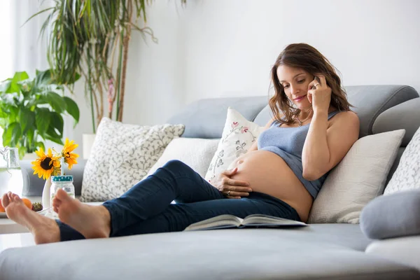 Jonge mooie zwangere vrouw spreken op de telefoon thuis in de — Stockfoto