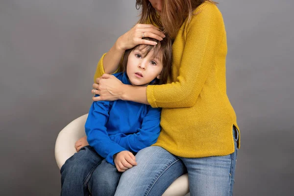 Грустное дитя, мальчик, обнимает мать дома, изолированный имаг — стоковое фото