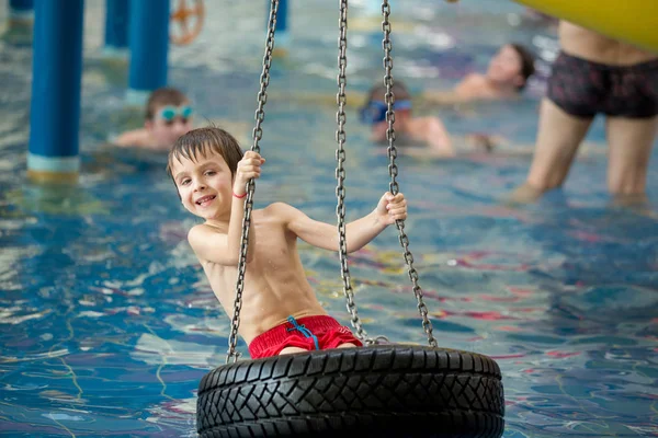 Солодка дитина, хлопчик, грає у водному світі ігровий майданчик, насолоджуючись — стокове фото
