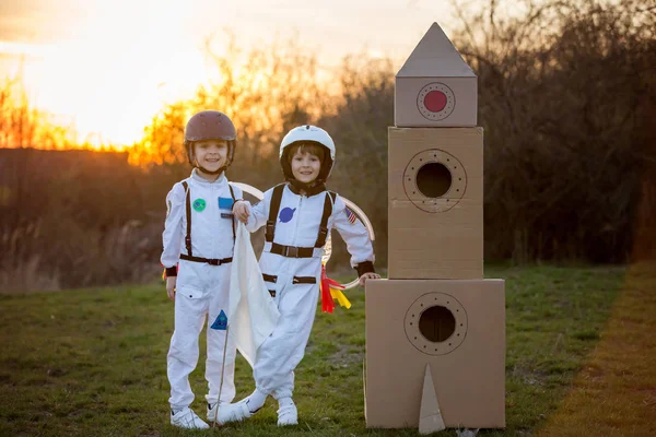 Dos niños adorables, jugando en el parque al atardecer, vestidos como un —  Fotos de Stock