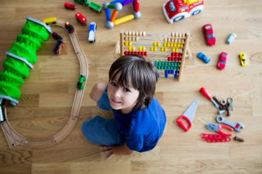 Okul öncesi çocuk abaküs ve oturan diğer oyuncakları ile oynarken, 