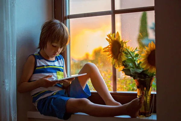 Aranyos kis tipegő gyermek, játék tábla egy ablakban — Stock Fotó