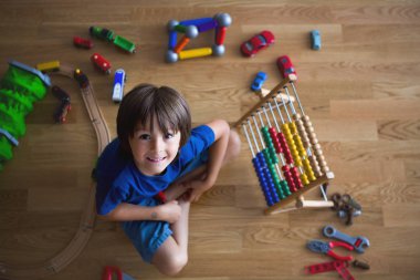 Okul öncesi çocuk abaküs ve oturan diğer oyuncakları ile oynarken, 