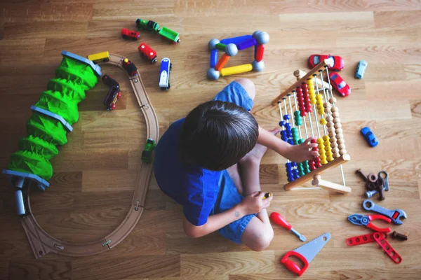 Criança pré-escolar, brincando com ábaco e outros brinquedos, sentado em — Fotografia de Stock