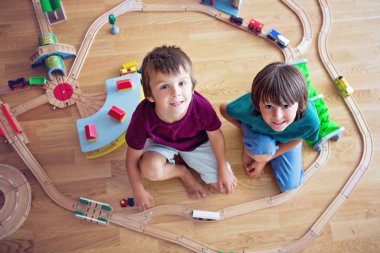 Tatlı okul öncesi çocuklar ahşap demiryolu ile oynarken, erkek kardeşler,