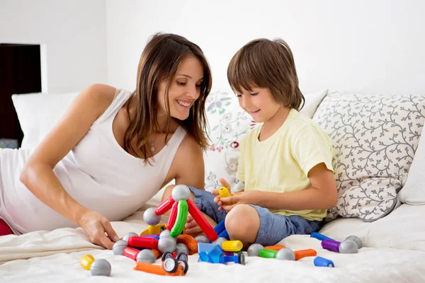 在室内玩在一起的可爱怀孕的母亲和孩子男孩 — 图库照片