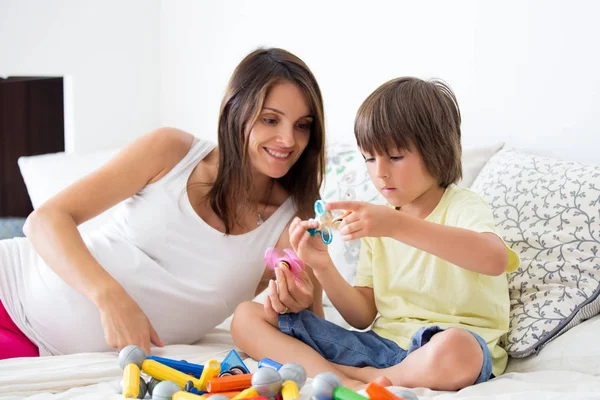 Genç hamile anne ve oğlu topluca spinners Viyadükler ile oynamak