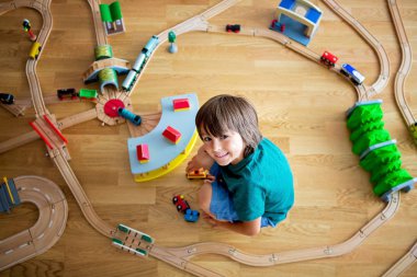 Tahta tren ve tren ile oynayan tatlı okul öncesi çocuk,